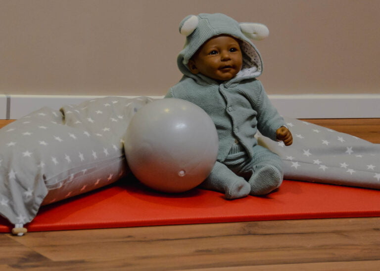 Puppe mit Gymnastikball auf der Matte